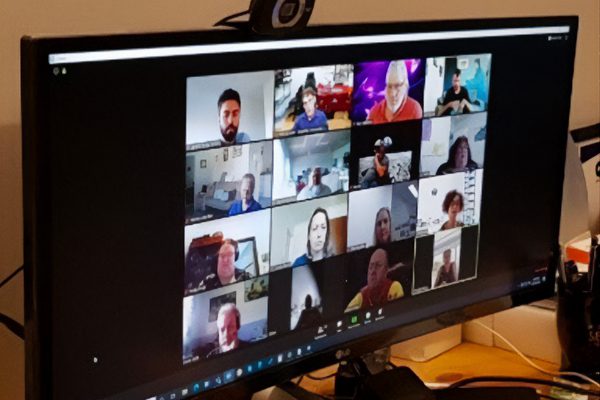 A computer monitor with a Zoom meeting in progress with 16 people's profiles on screen.