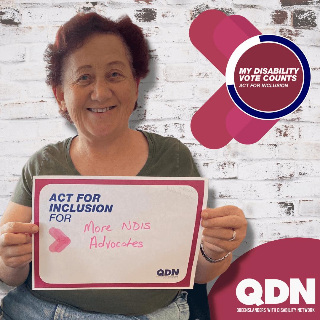 Woman holding a sign saying Act for Inclusion for and hand written it says "More NDIS advocates" There is a QDN logo in the bottom right, Queenslanders with Disability Network. In the top right it says My disability Vote Counts, Act for Inclusion.