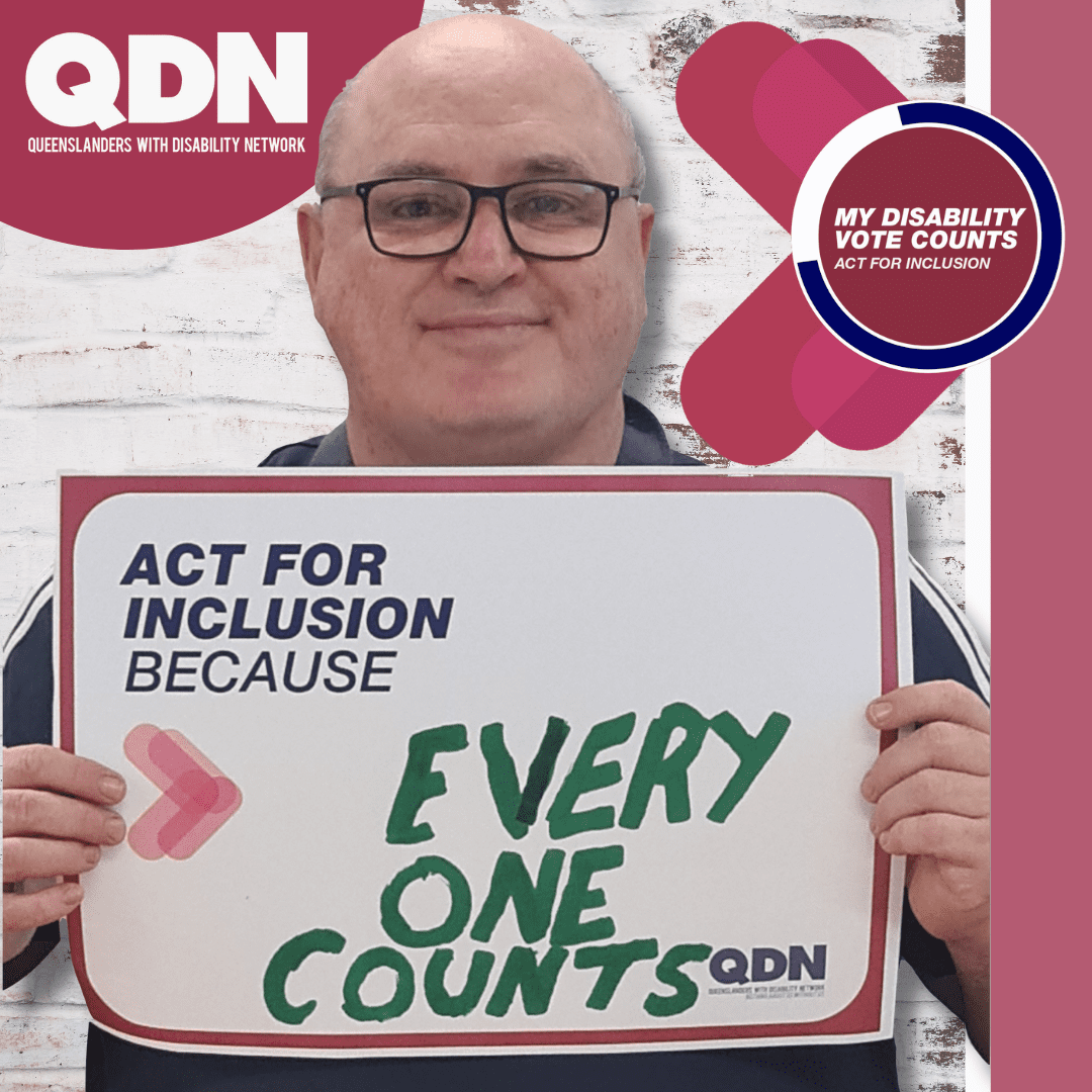 A man holding a sign that says Act for Inclusion because and he has written Everyone Counts. There is a QDN logo in the bottom right, Queenslanders with Disability Network. And in the top right it says My Disability Vote Counts, Act for Inclusion. 