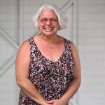 Woman wearing a colorful dress smiling at the camera