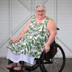 Elderly Woman sitting on a wheelchair smilling at the camera 