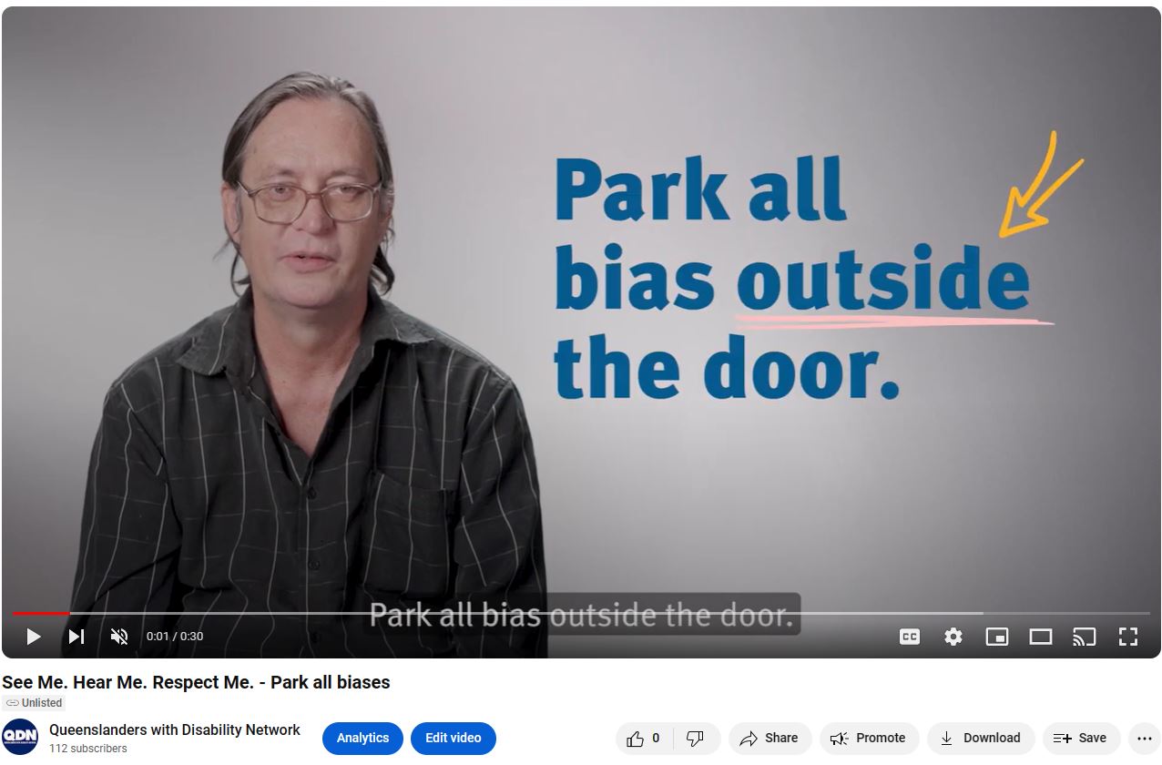 Screen clipping of linked YouTube video. There is a man to the left of the screen in a black collared shirt. To the right in navy blue text is Park all bias outside the door. At the bottom of the screen clipping there is the YouTube banner, with play, pause, skip buttons.