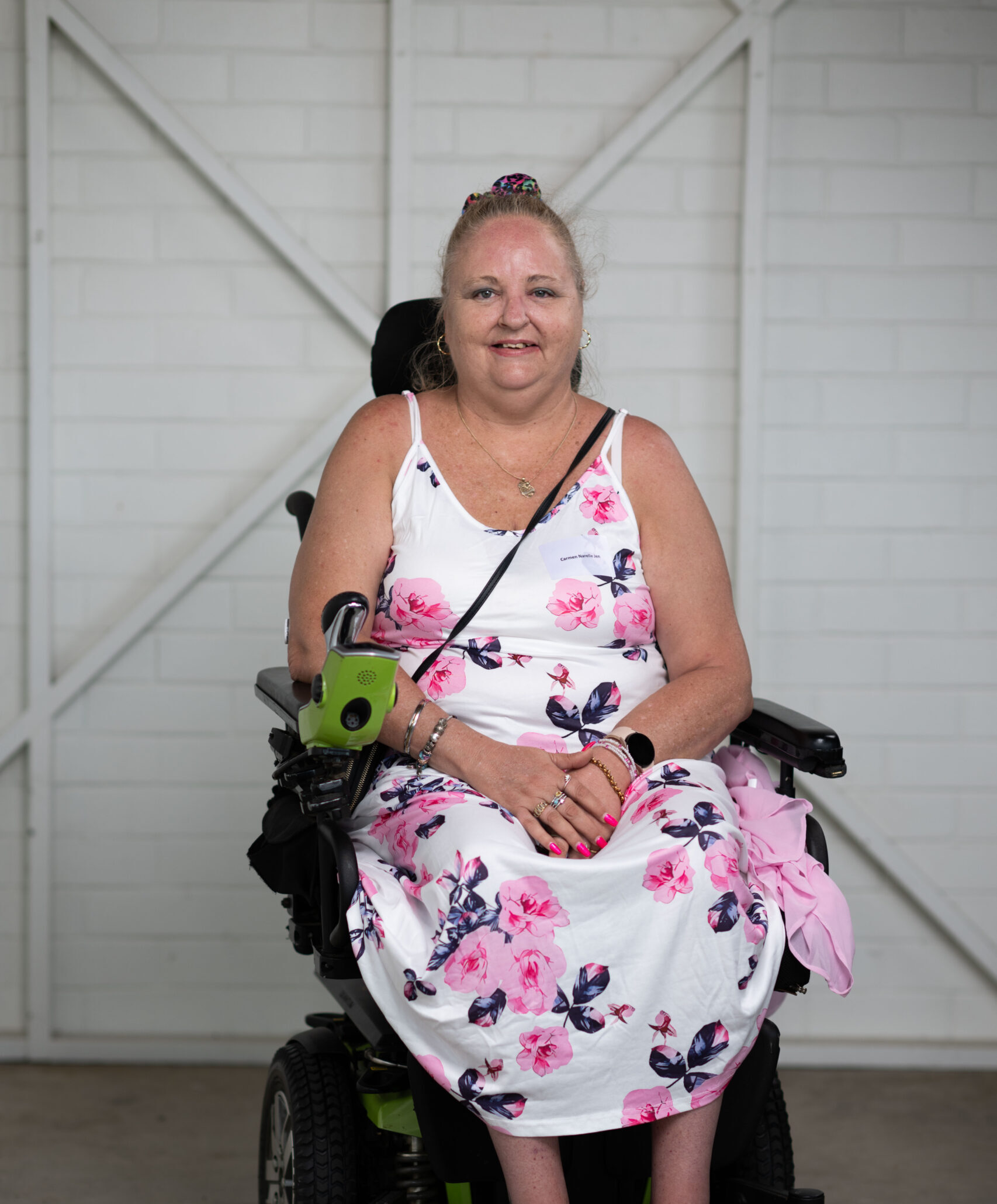 Woman sitting at her wheelchair smiling at the camera