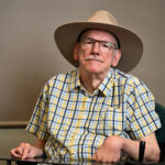 Man in a checked shirt with a hat and glasses