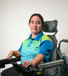 A woman in a green and yellow shirt in a wheelchair