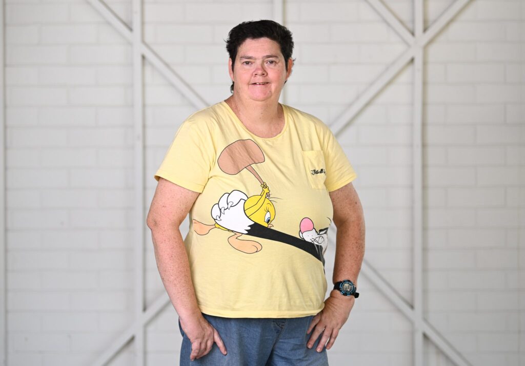 A woman in a yellow shirt with cartoons on it