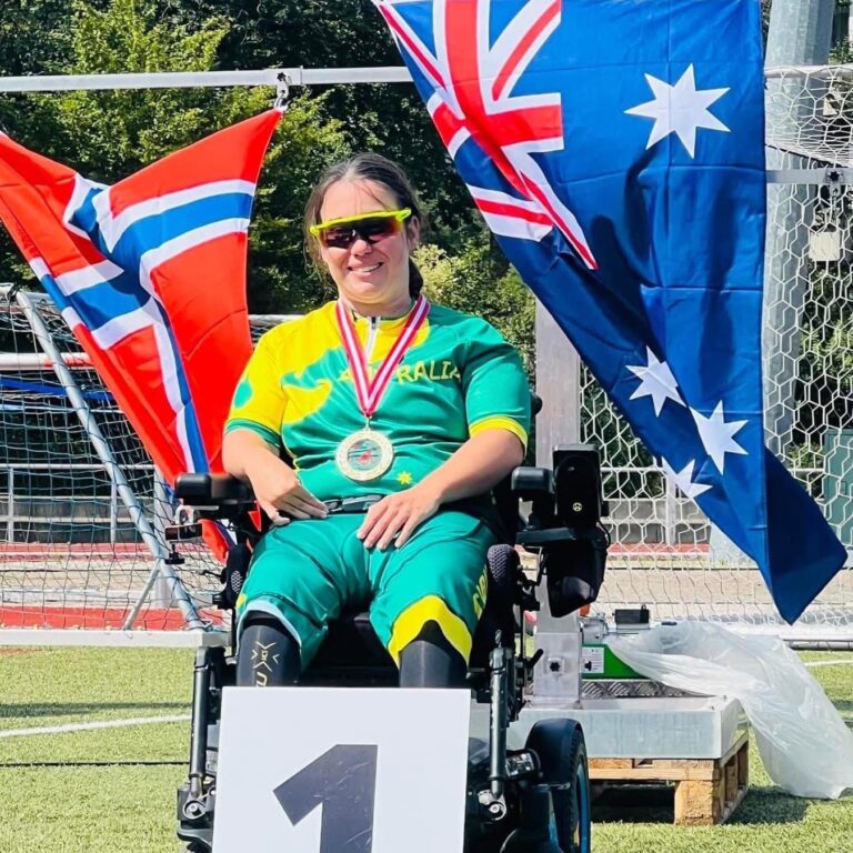 a woman in a wheelchair on the 1st place dais