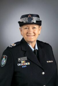 Detective Senior Sergeant Debbra Phillips is in her official uniform. Her hair is neatly tied back, and she smiles for the photo.